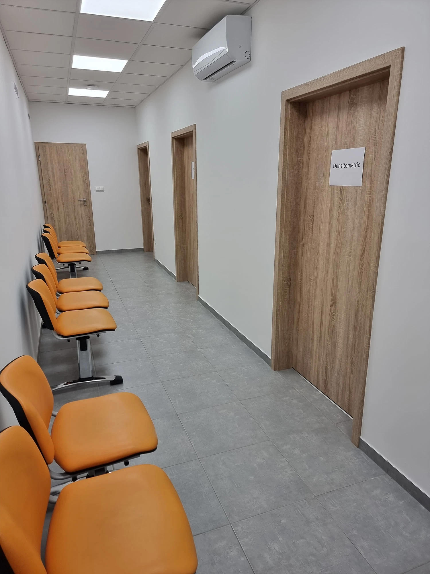 Chodba ambulance s čekárnou a dveřmi k místnosti densitometrie